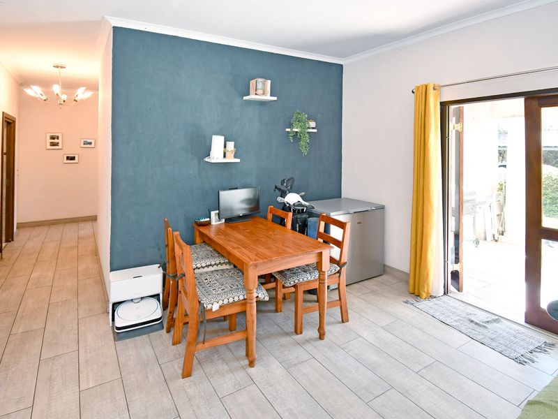 A living area featuring tiled flooring, a blue accent wall, and a sliding glass door providing direct access to the outdoor patio.