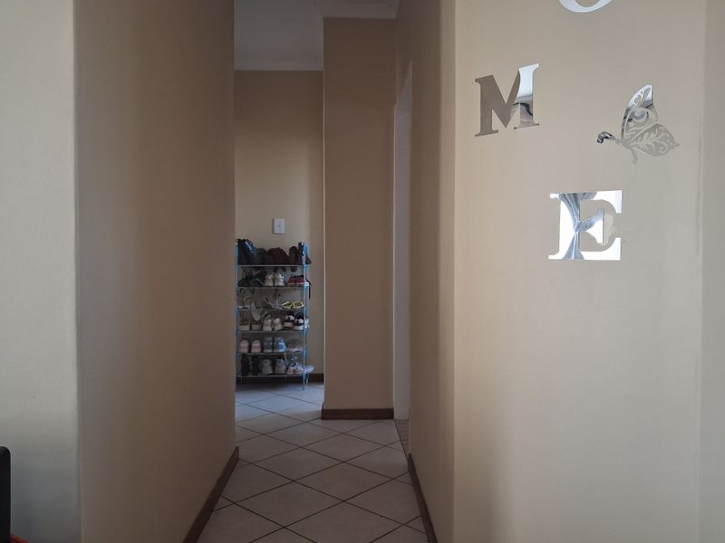 A functional hallway featuring neutral wall tones and tiled flooring, providing a clean transition between living spaces.