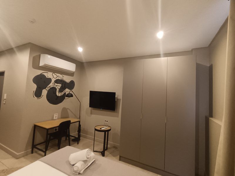 A well-maintained bedroom featuring a built-in wardrobe, split-system air conditioning, and modern recessed lighting.