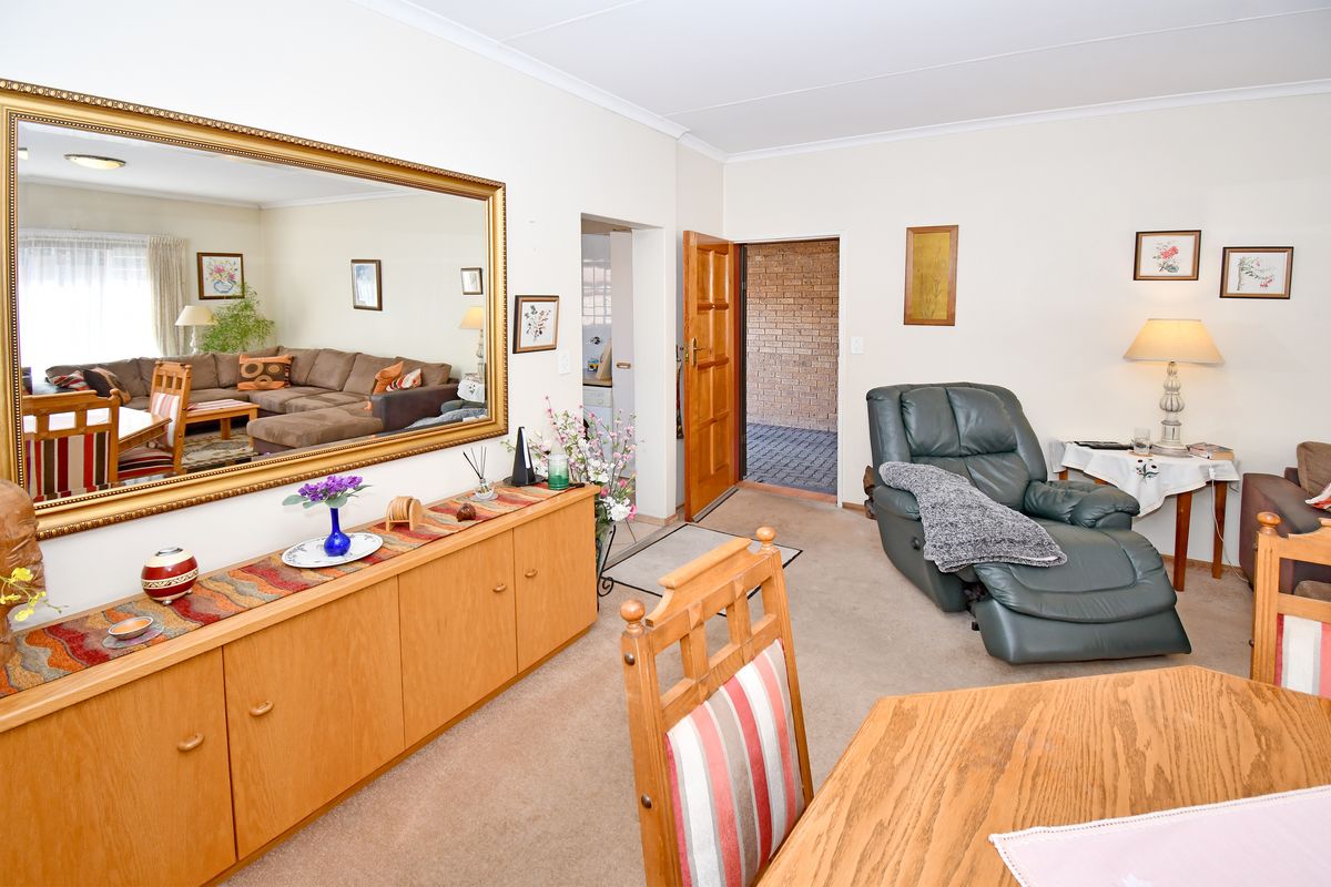 A comfortable living area featuring neutral walls, coved ceilings, and built-in cabinetry, providing a functional space with direct access to the exterior.