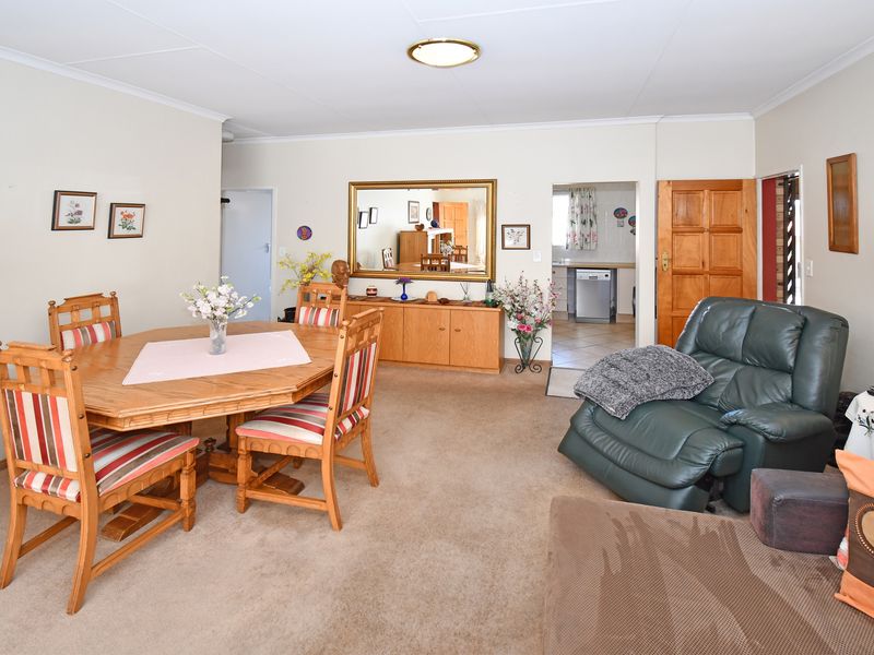 Open plan living and dining area featuring carpeted flooring and access to the kitchen area.