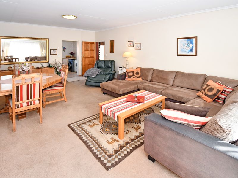 Spacious open-plan living and dining area featuring neutral wall finishes and carpeted flooring, providing a versatile layout for family living.