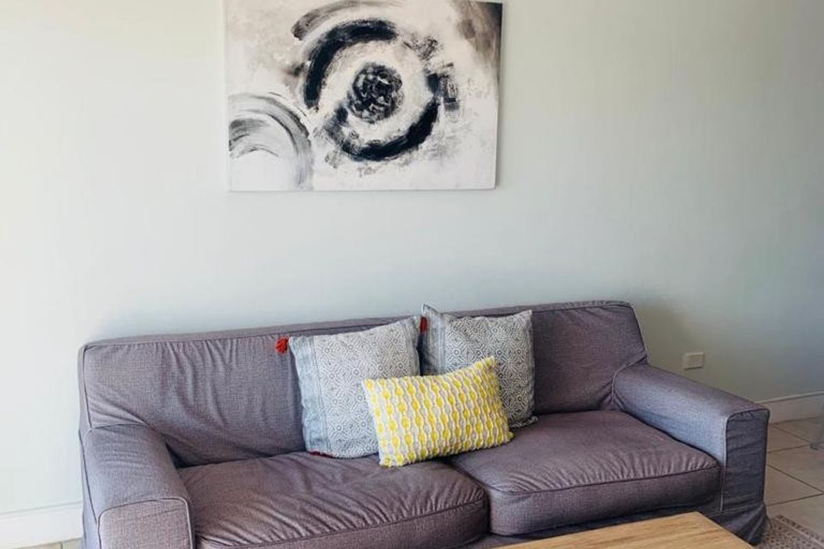 A living room area featuring neutral wall tones and tiled flooring, providing a functional and comfortable space for relaxation.
