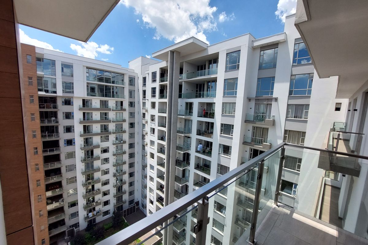 View from a high-rise apartment balcony overlooking the complex courtyard and surrounding residential building facades.