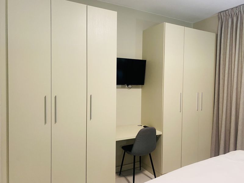 A bedroom featuring ample storage with integrated built-in wardrobes and a functional built-in desk area.