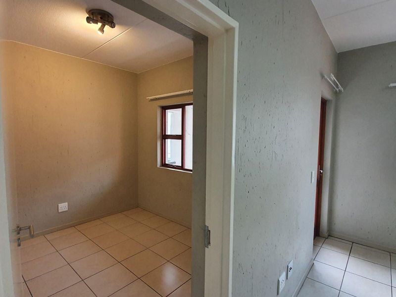 An empty bedroom featuring tiled flooring and neutral walls, offering a blank canvas for personalization and interior design updates.
