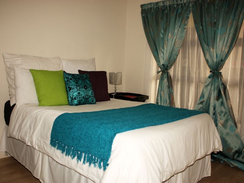 A standard bedroom featuring neutral walls and laminate flooring, providing a functional and comfortable sleeping space.