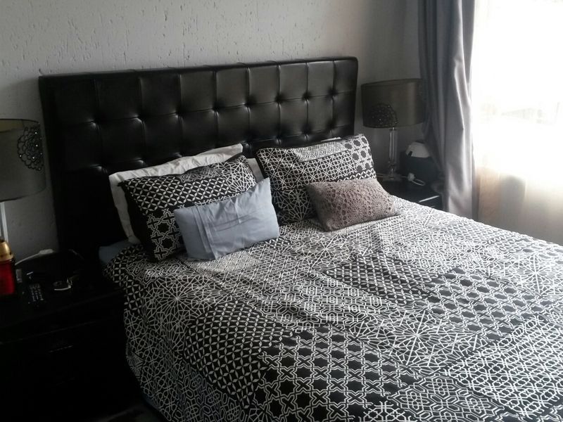 A bedroom featuring textured wall finishes and natural light from the window.