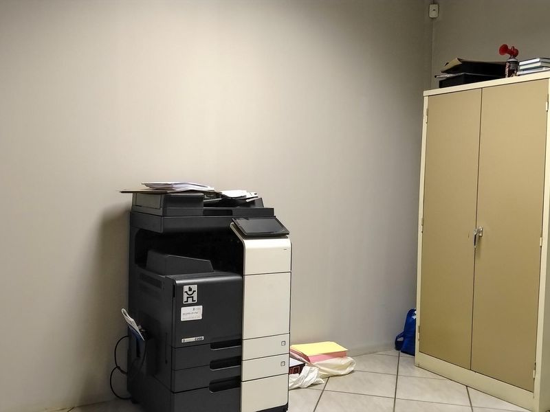A functional office space featuring tiled flooring and neutral wall finishes, suitable for a variety of professional uses.