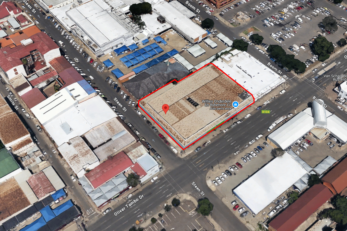 Aerial view of a commercial property located on a corner lot in an urban retail district, highlighting the building footprint and surrounding street infrastructure.