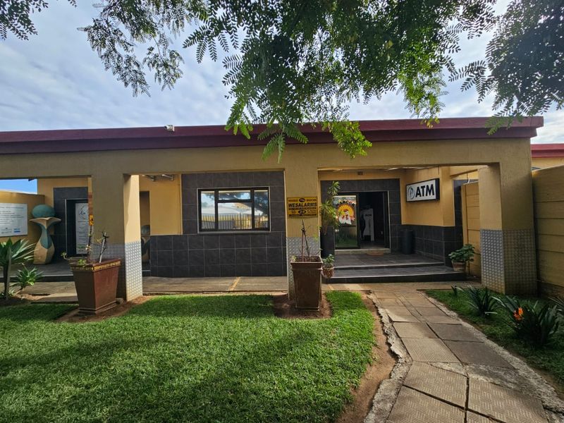 Front exterior view of a commercial property featuring a covered patio, paved walkway, and integrated ATM facility.
