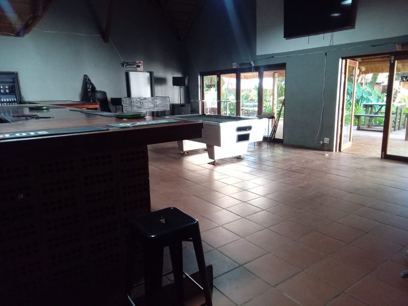 Spacious bar area featuring a built-in counter, tiled flooring, and large glass sliding doors providing direct access to the outdoor patio.