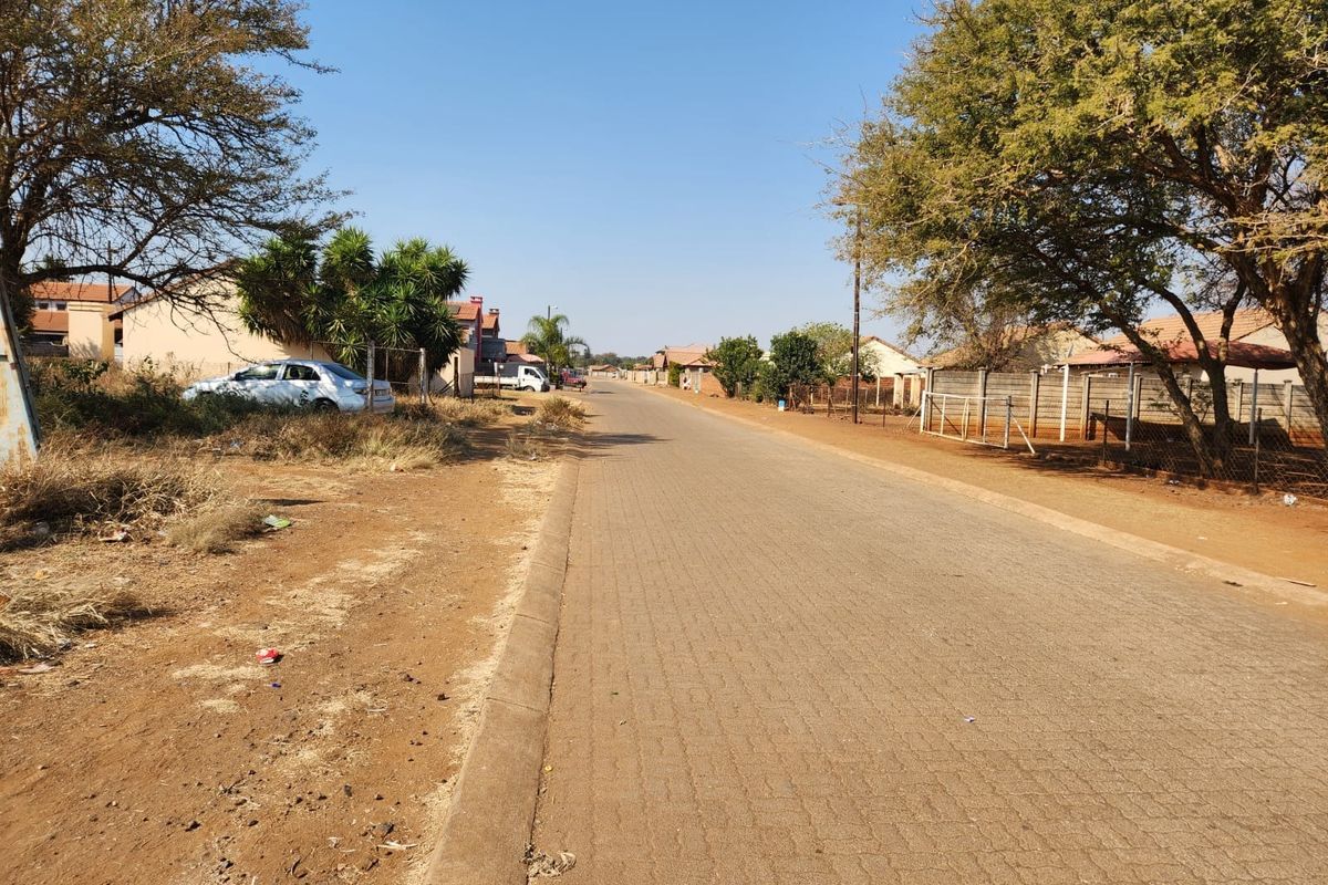 A view of the paved street and surrounding residential neighborhood infrastructure.