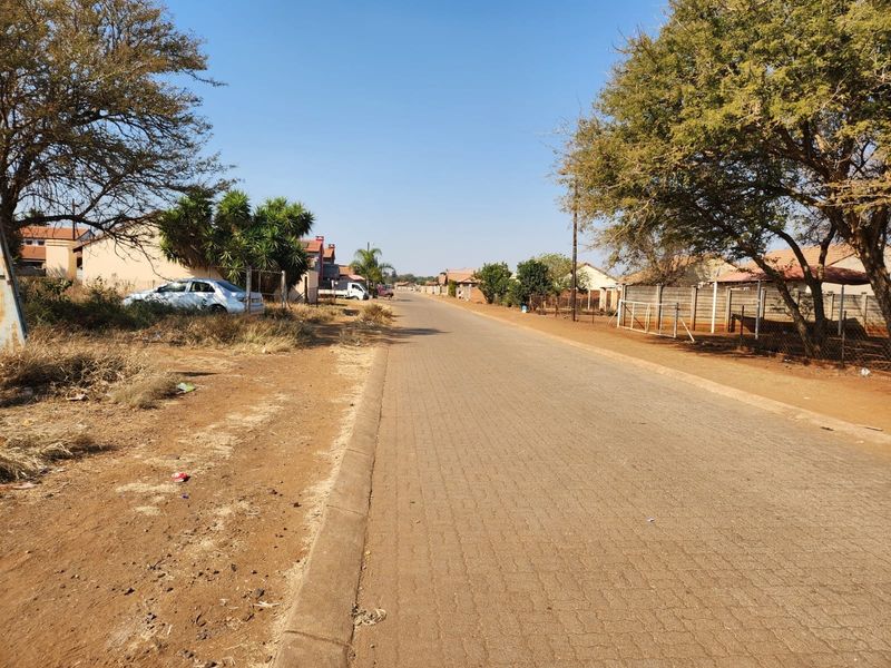 A view of the paved street and surrounding residential neighborhood infrastructure.