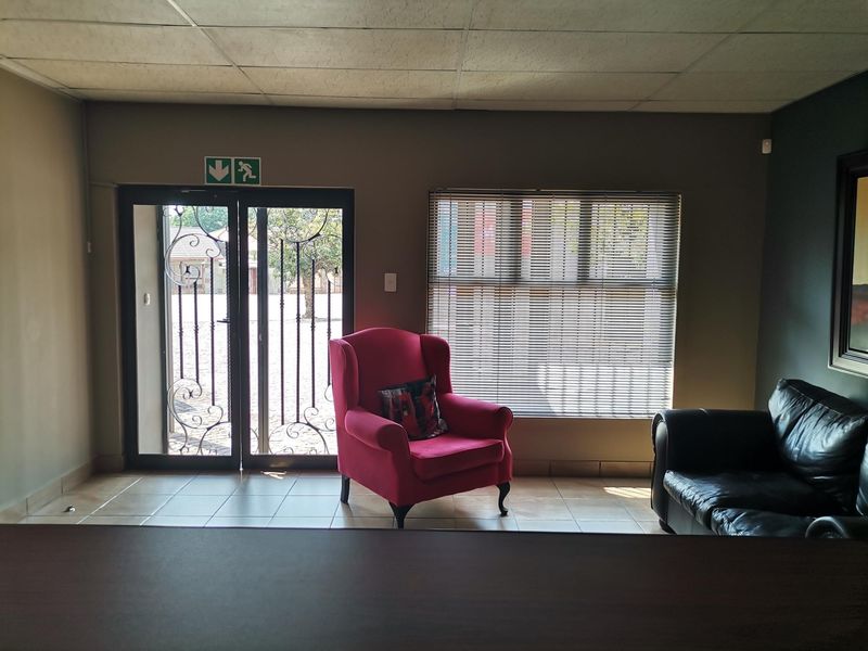 Office space featuring tiled flooring, a suspended ceiling, venetian blinds, and a secure aluminium-framed glass entrance door.