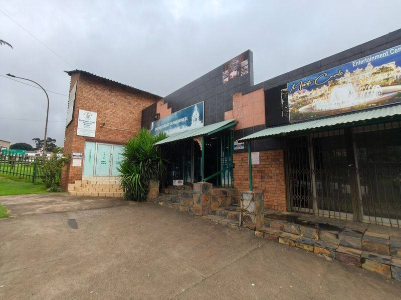 Front exterior view of a commercial guest house property featuring brick facade, tiled entrance steps, and metal security gates.