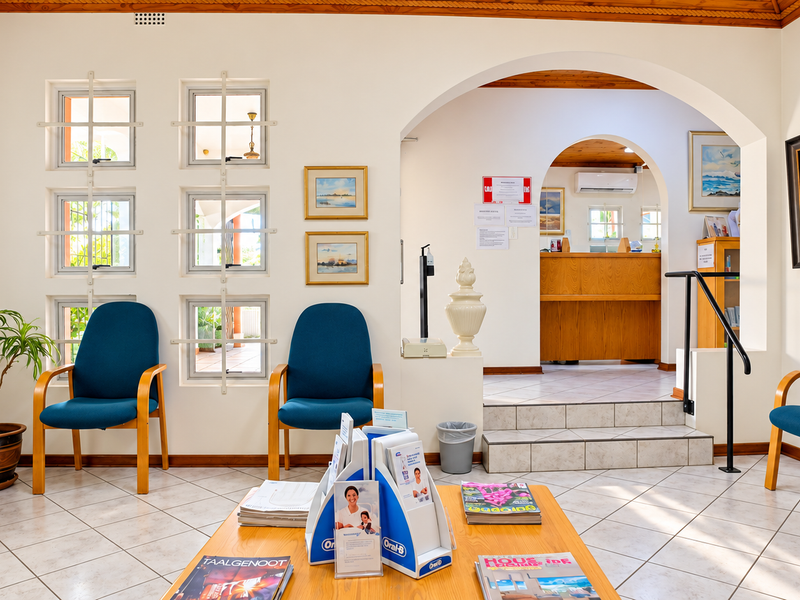 A welcoming office reception area featuring tiled flooring, an arched transition to the main desk, and natural light through multiple windows.