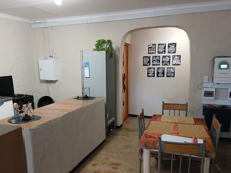 Open-plan living and dining area featuring a built-in breakfast bar, arched doorway, and integrated solar power infrastructure.