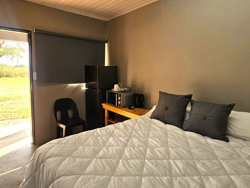 A bedroom featuring a timber door with direct outdoor access, a roller blind, and a tongue and groove ceiling.