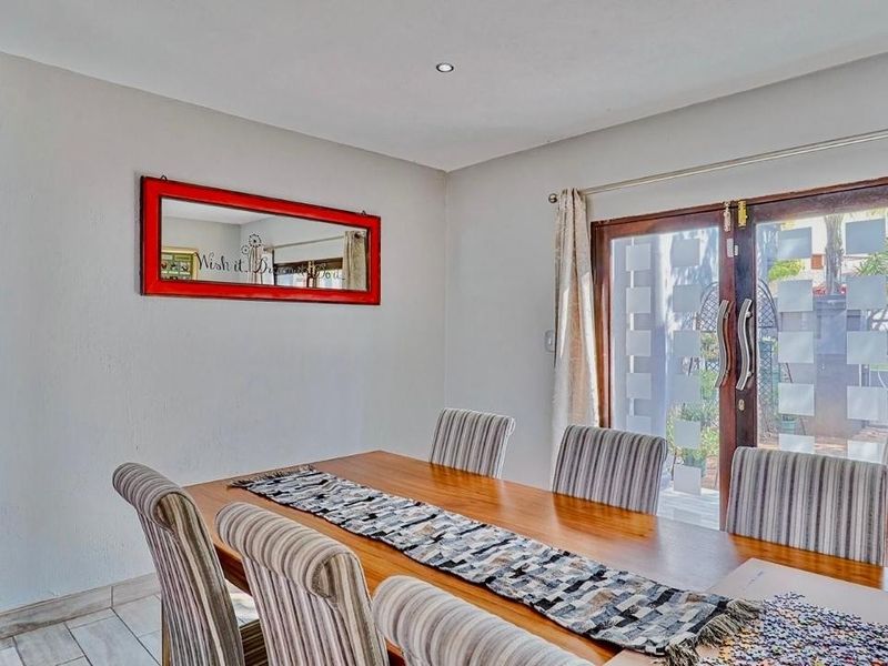 A dining room featuring tiled flooring, recessed lighting, and wooden framed glass sliding doors providing access to the outdoor area.