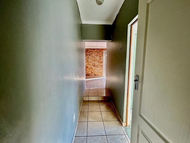 A functional hallway featuring tiled flooring and neutral wall finishes, providing a clear transition between living areas.