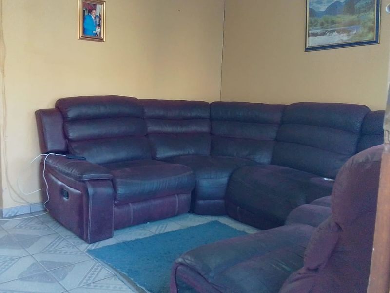 A living room area featuring tiled flooring and neutral wall paint, providing a functional space for relaxation.