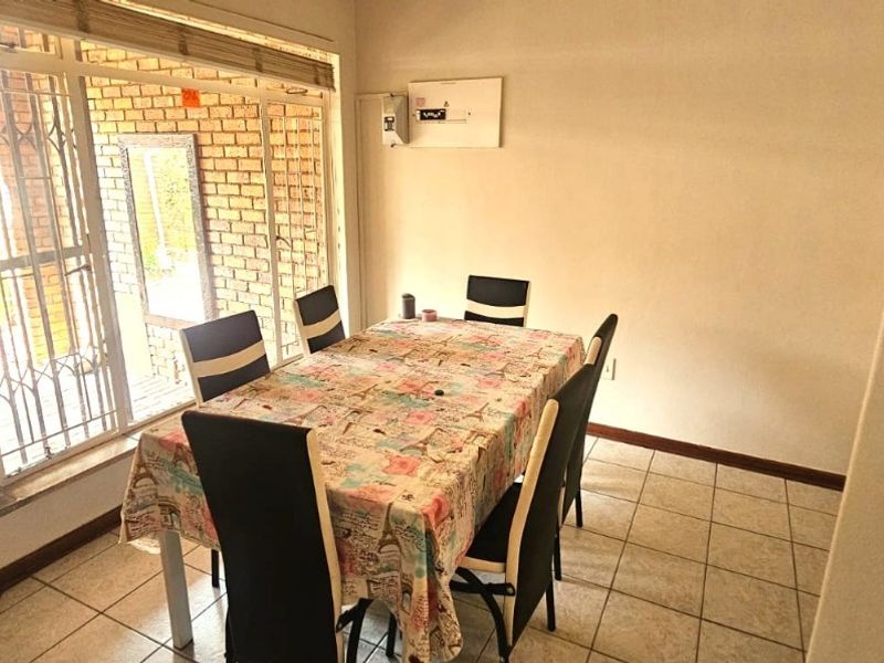 Dining area featuring tiled flooring, a sliding door with security gate, and access to an outdoor space.