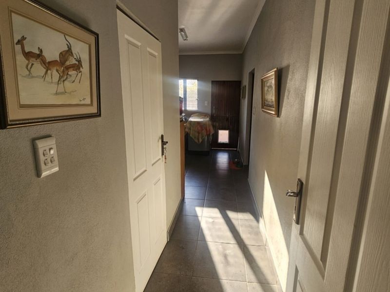 A functional hallway featuring tiled flooring and neutral wall finishes, providing access to various rooms within the home.