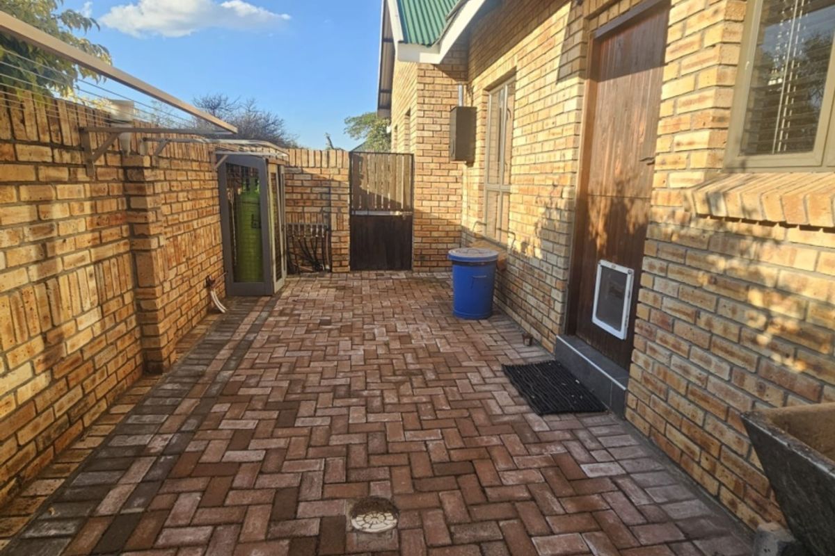 A private rear courtyard featuring durable face brick walls and neat paving, providing a secure and low-maintenance outdoor utility space.
