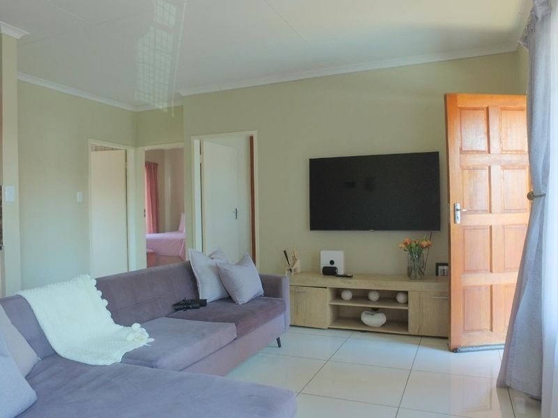 Open plan living area featuring tiled flooring, coved ceilings, and direct access to adjacent rooms and kitchen space.