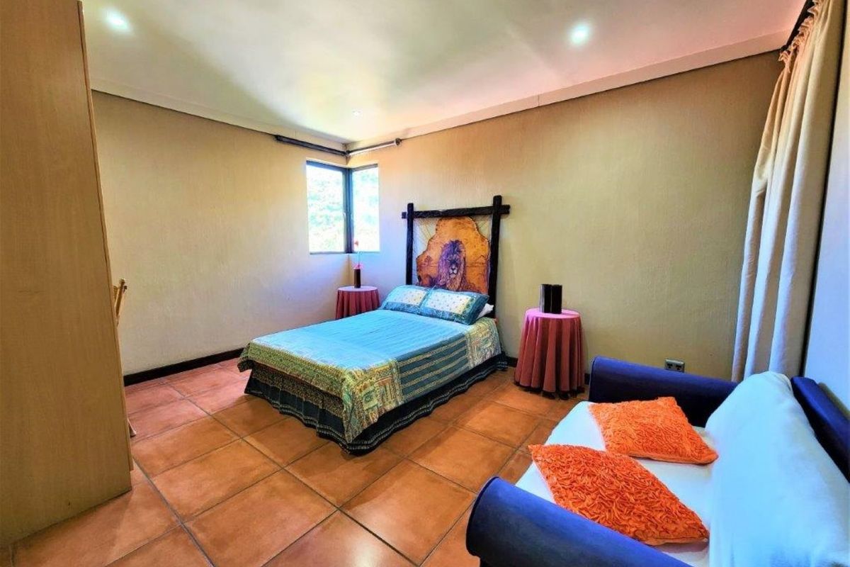 A bedroom featuring terracotta floor tiles, recessed ceiling lighting, and built-in cabinetry.