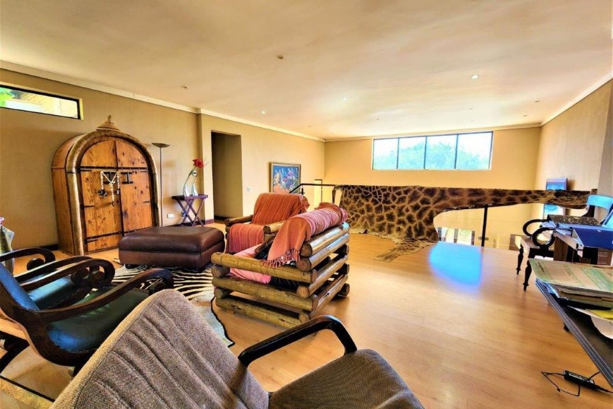 Spacious living area featuring laminate flooring and recessed downlighting, offering an open layout with a staircase overlook.