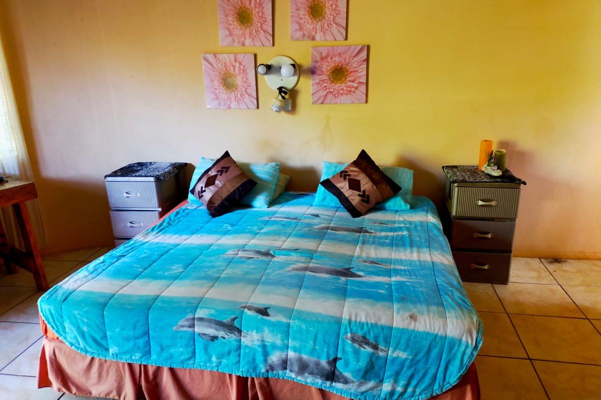 A bedroom featuring tiled flooring and a central wall-mounted light fixture, providing a functional sleeping space within the farm property.