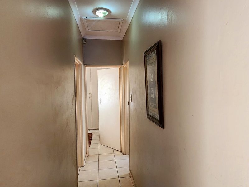 A functional interior hallway featuring tiled flooring and access to adjacent rooms, providing a central circulation path within the townhouse.