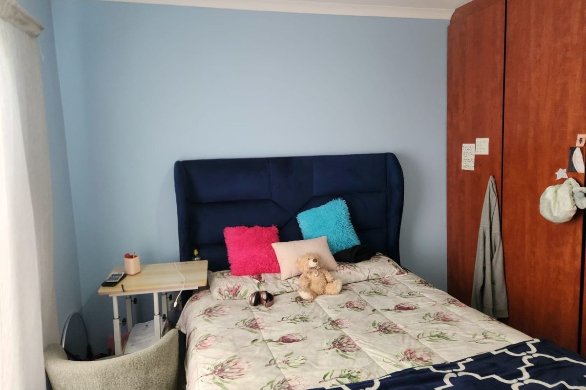 A bedroom featuring built-in wooden cabinetry and light blue wall paint.