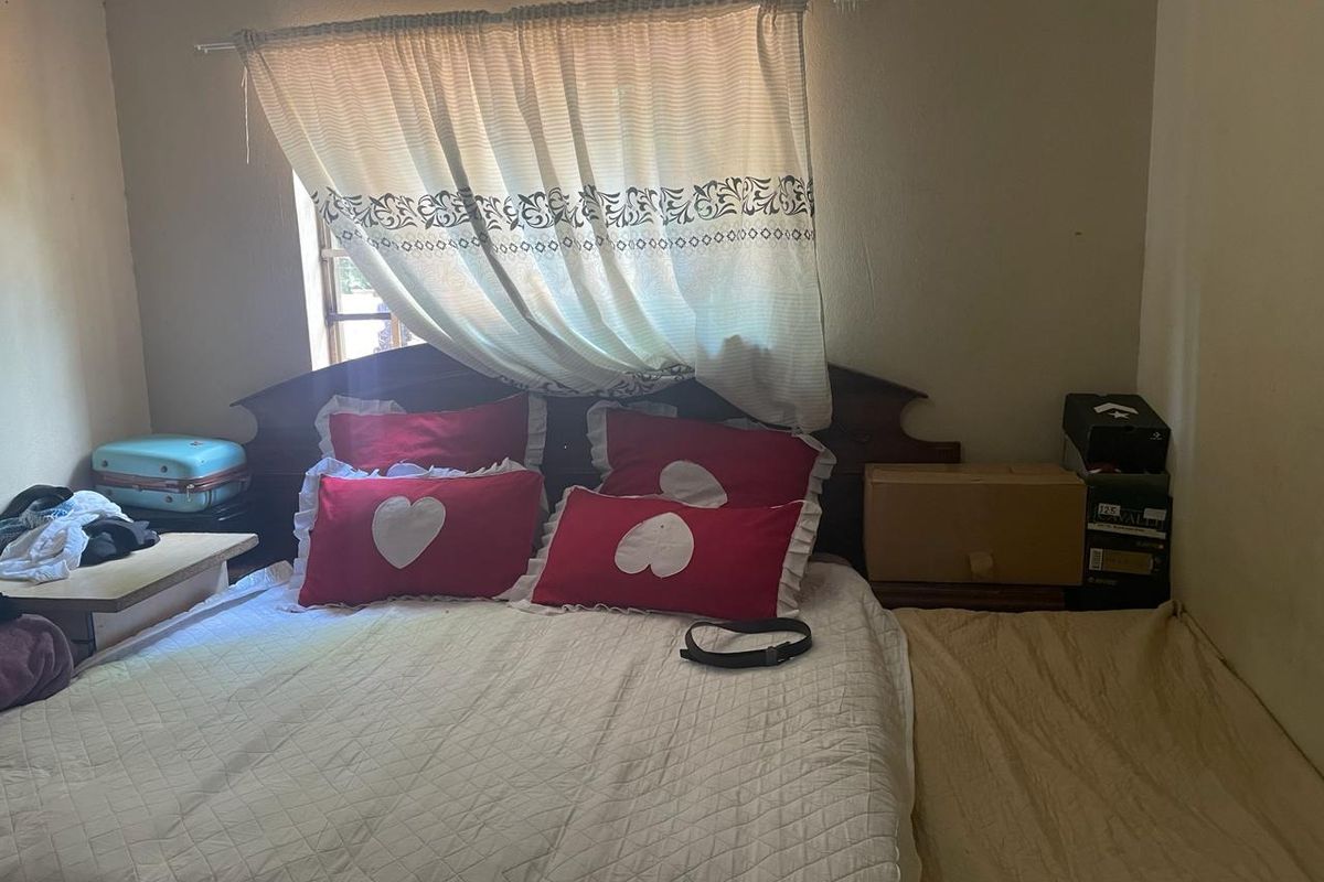 A bedroom featuring a window with a curtain and basic wall finishes.
