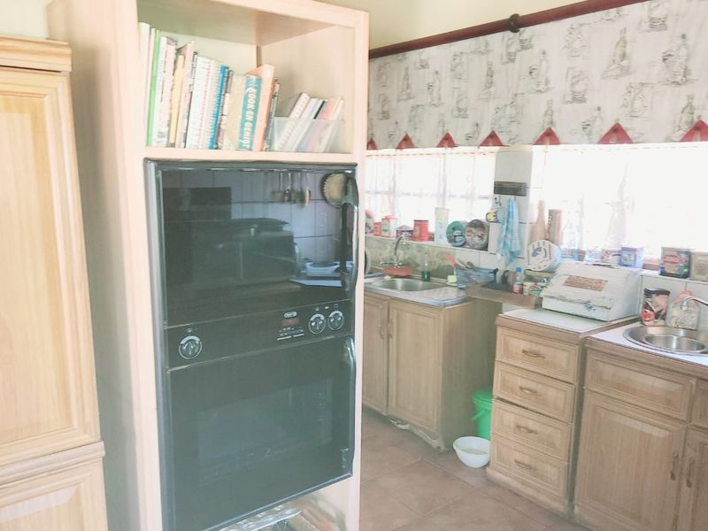 A functional kitchen featuring built-in cabinetry, a double oven, and dual stainless steel sinks with tiled splashbacks.