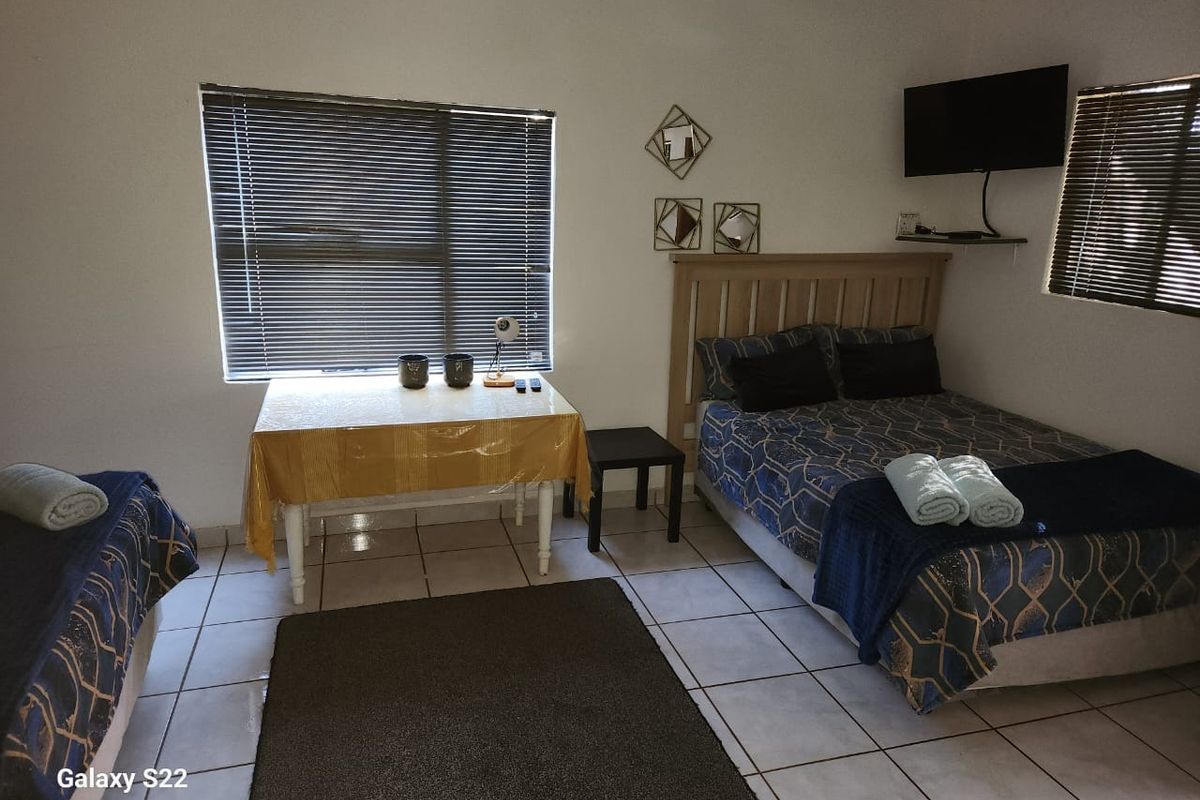 A bedroom featuring tiled flooring, horizontal window blinds, and a wall-mounted television bracket.