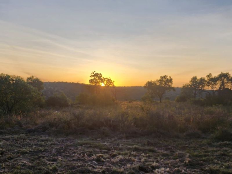 A scenic view of the vacant residential land at sunset, showcasing the natural landscape and surrounding vegetation.