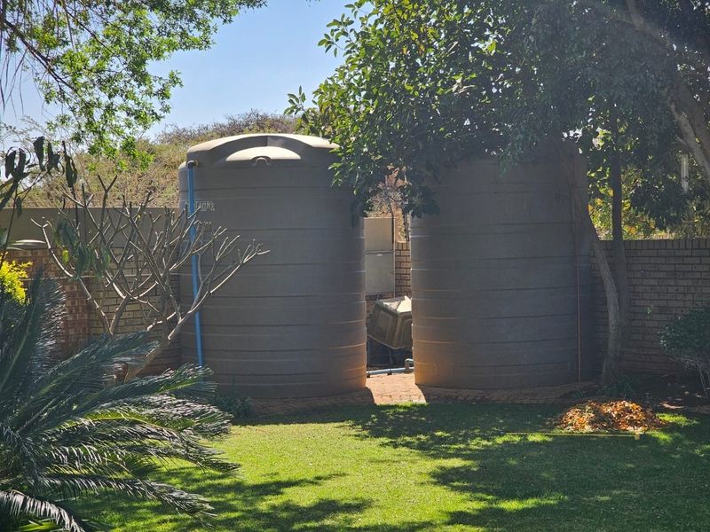 Two large water storage tanks situated in the rear garden area, providing functional water management infrastructure for the property.