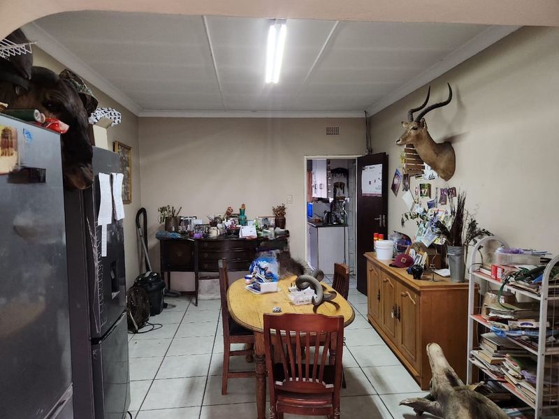 Dining room area featuring tiled flooring and direct access to the kitchen, offering a functional space for family meals.
