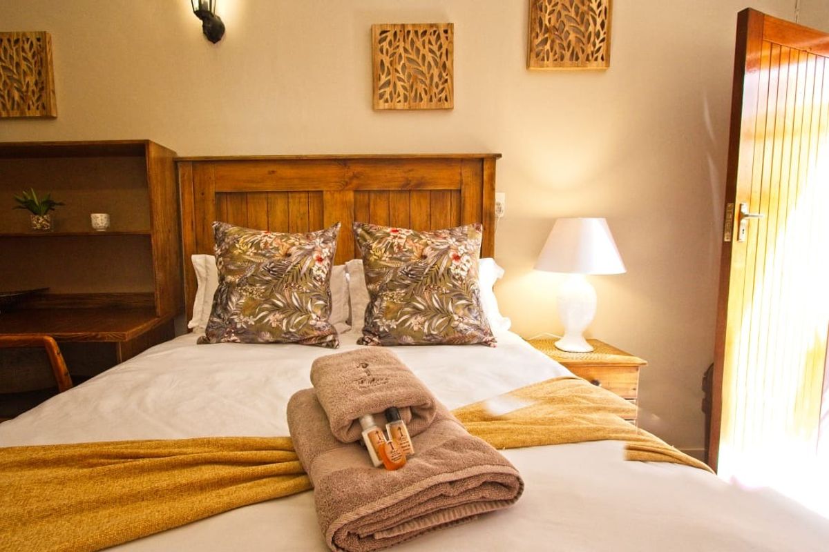 A cozy bedroom featuring a built-in wooden headboard, integrated desk space, and a solid wooden door, creating a warm and functional sleeping area.
