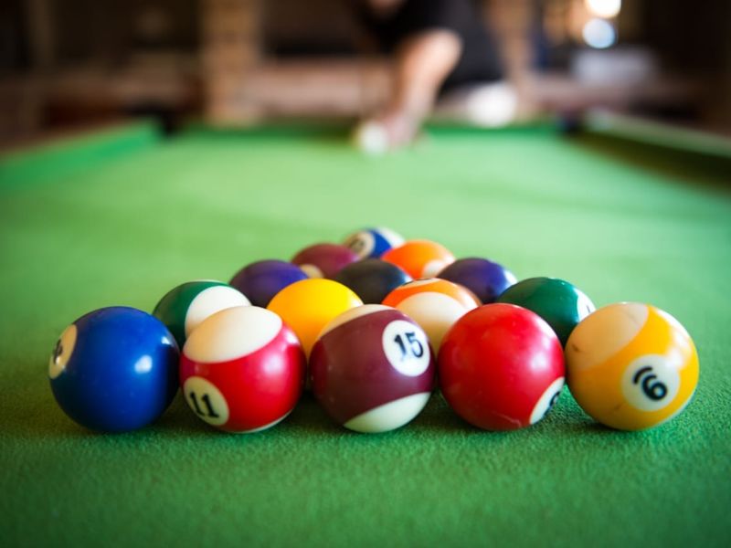 A close-up shot of a pool table with billiard balls arranged for a game.