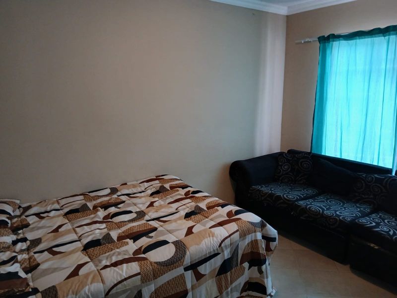 A bedroom featuring tiled flooring and a curtain rail, providing a functional space with neutral wall finishes.