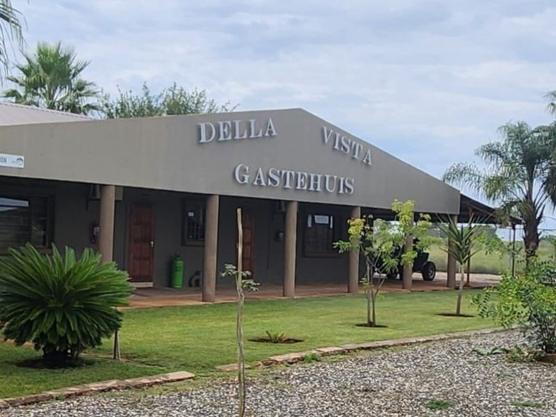Front elevation of the Della Vista Gastehuis featuring a covered veranda, structural columns, and a well-maintained garden area.