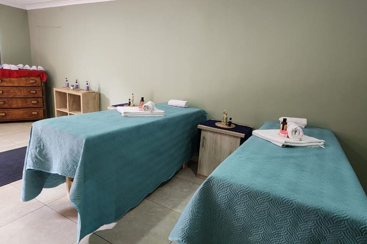A functional room currently utilized as a treatment space, featuring neutral wall tones, tiled flooring, and roller blinds.