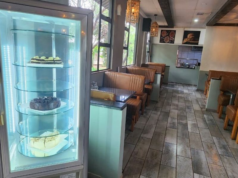 A well-maintained dining area featuring tiled flooring, built-in booth seating, and large windows, creating a functional and inviting space for guests.