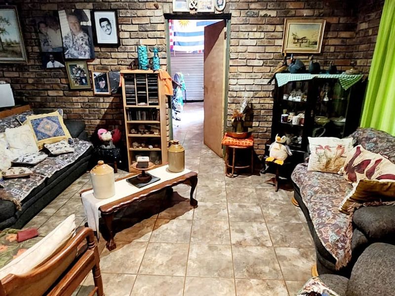 A living room featuring rustic exposed brick walls and tiled flooring, offering a cozy and traditional atmosphere.