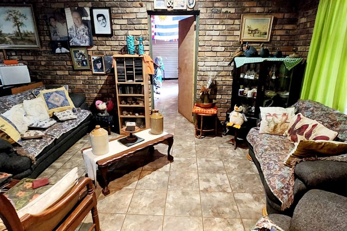 A living room featuring rustic exposed brick walls and tiled flooring, offering a cozy and traditional atmosphere.