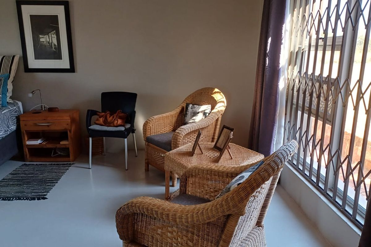 A bedroom featuring polished concrete flooring and a sliding door with a fitted security gate, providing access to the exterior.